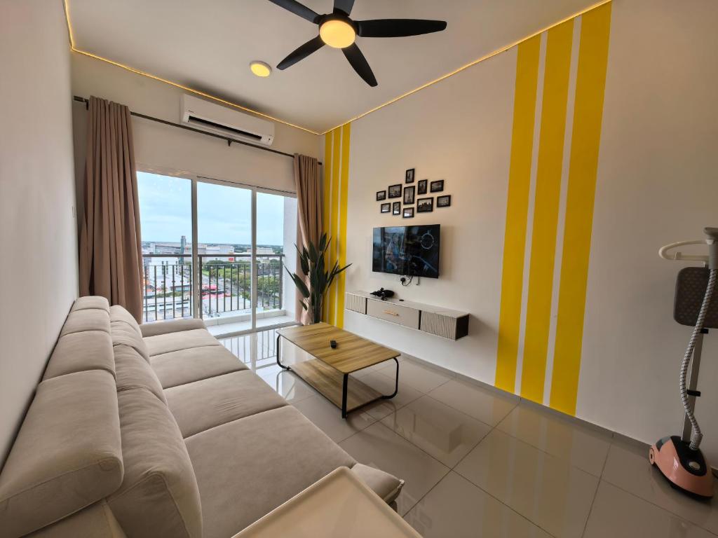 un salon avec un canapé et une grande fenêtre dans l'établissement Alor Setar Tower 3 Bedroom Suite, à Alor Setar