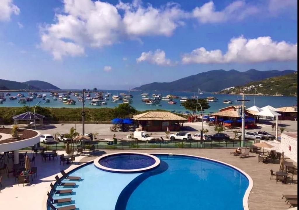Una vista de un complejo turístico con piscina y puerto. en Cobertura com Piscina Privativa em Resort Pé na Areia, en Arraial do Cabo