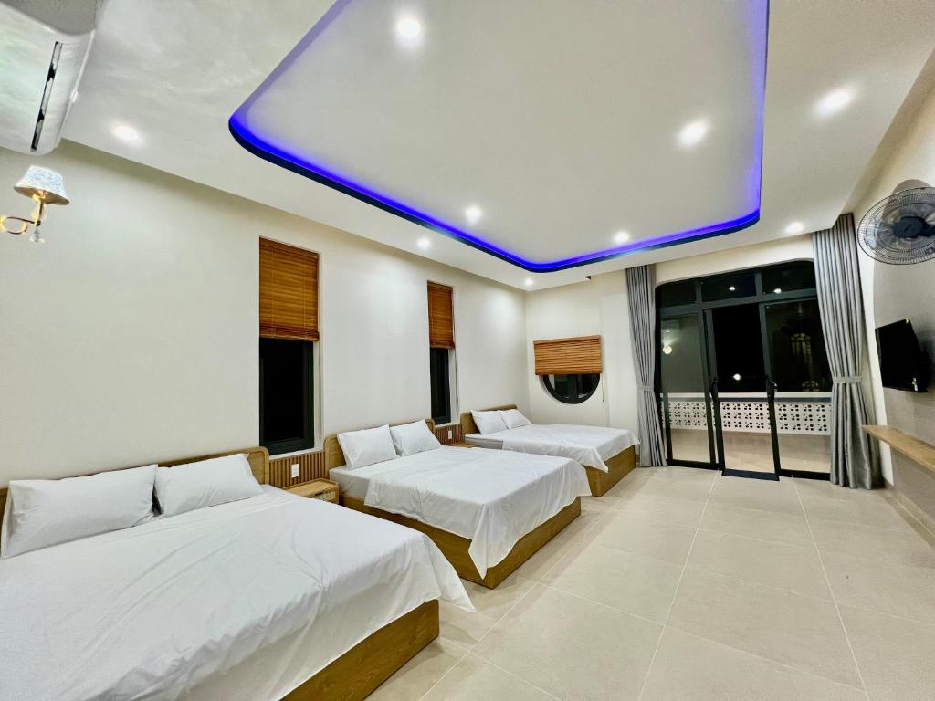 une chambre d'hôtel avec deux lits et un plafond bleu dans l'établissement Villa sát biển, 6pn, 9 giường, 7 toilet, hồ bơi riêng, bãi biển, sân vườn, à Tiến Thành