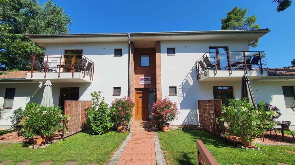 een groot wit huis met een bakstenen loopbrug bij Apartments in Szantod - Balaton 35823 in Szántód
