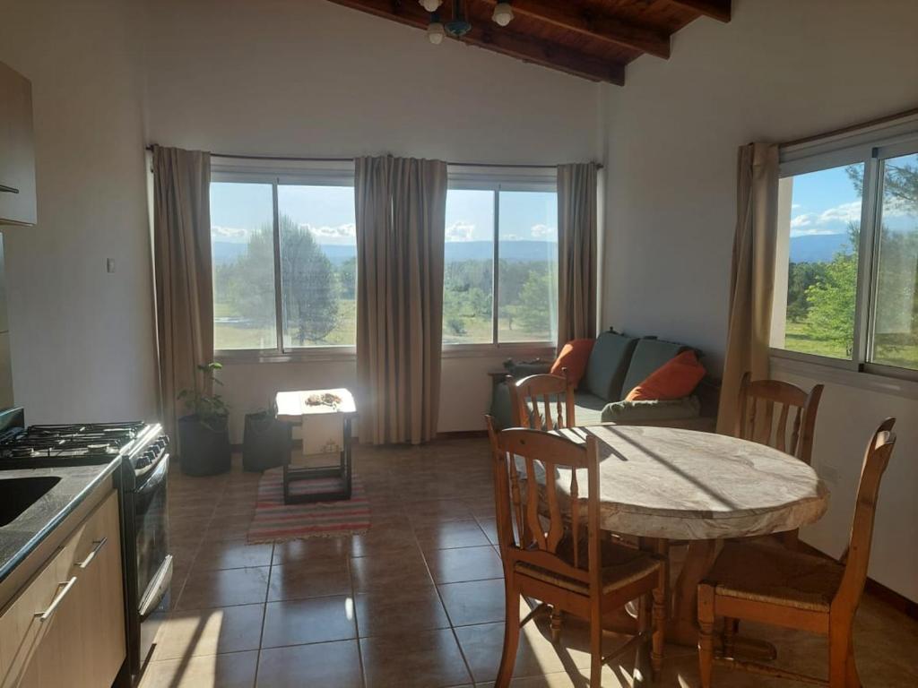 een keuken en woonkamer met een tafel en stoelen bij Bosquemolinos in Villa Los Molinos