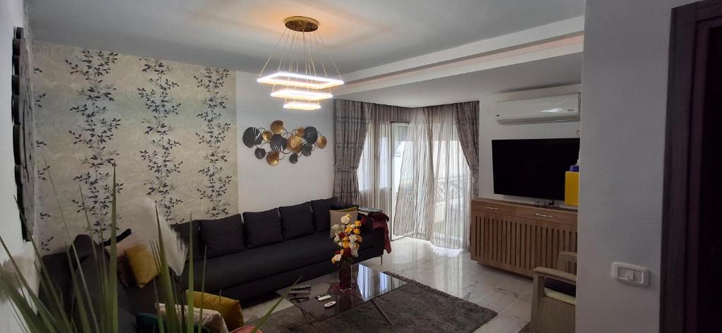 a living room with a couch and a television at Modern & Comfortable Apartment in Aouina in El Aouina Station
