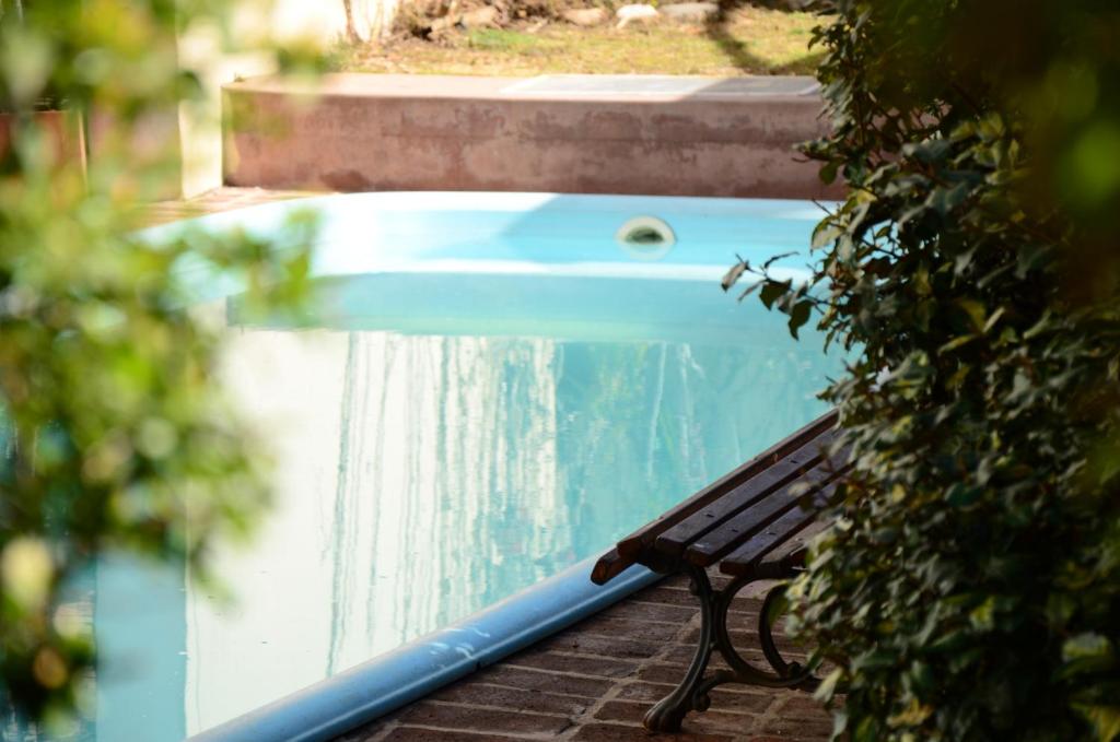un banco sentado junto a una piscina en Hotel Italia en Villa Carlos Paz