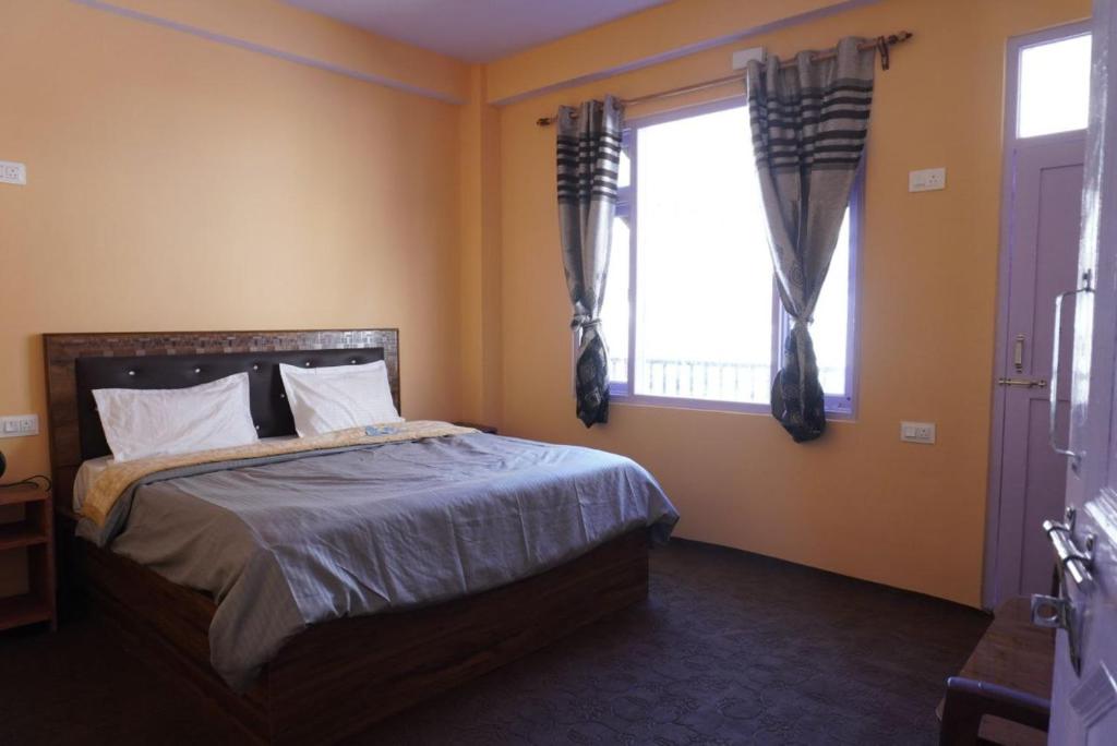 a bedroom with a bed and a window at Madhurvi baker's and homestay in Chitkul