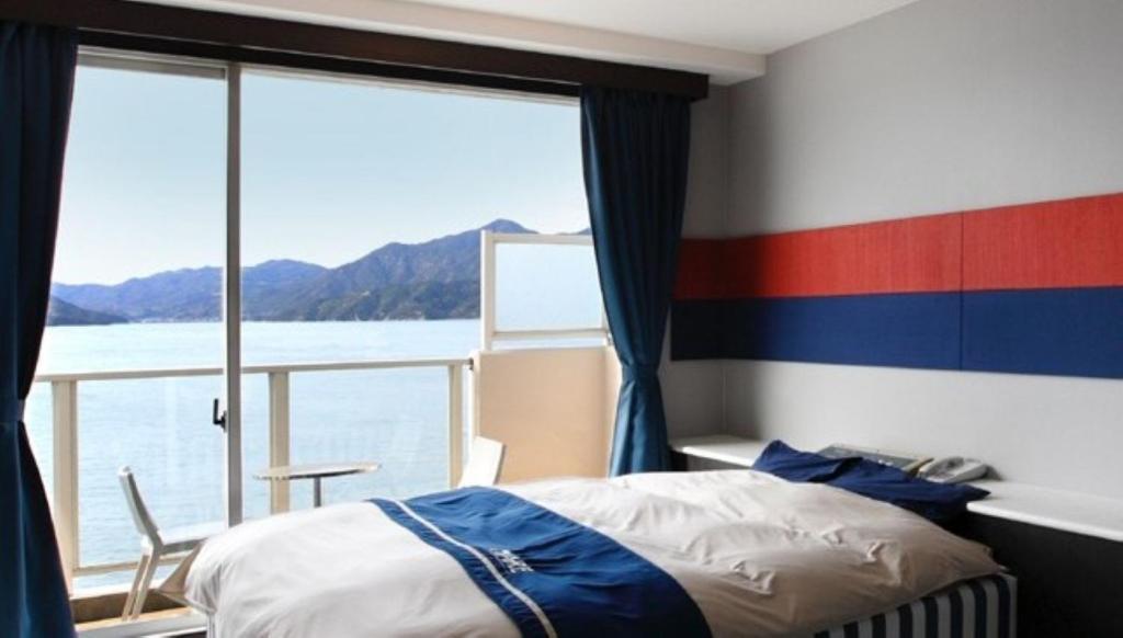 Un dormitorio con una cama y vista al agua. en Hotel Mare - Vacation STAY 59171v, en Mitsuguchi