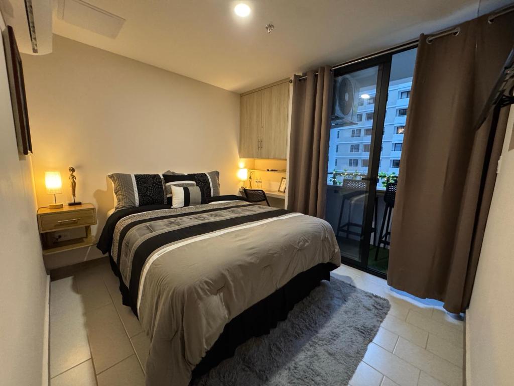 a bedroom with a bed and a large window at Moderno y nuevo apartamento en Lirios de Miraflores in Tegucigalpa