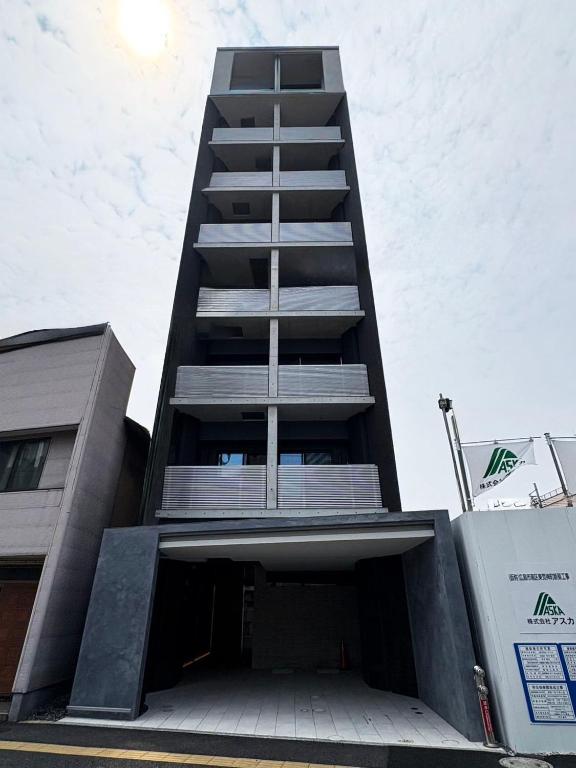 a tallartment building with a parking garage in front of it at OUCHI HOTEL Hiroshima Station in Hiroshima