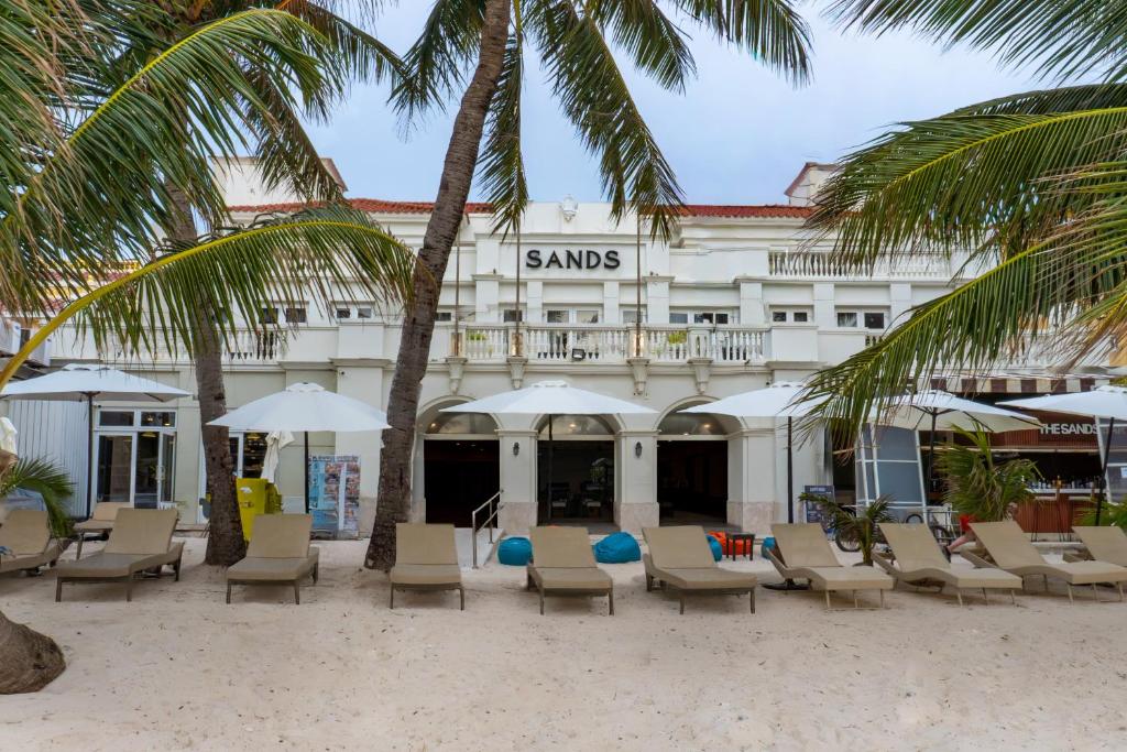 a hotel with chairs and umbrellas and palm trees at Boracay Sands Hotel in Boracay