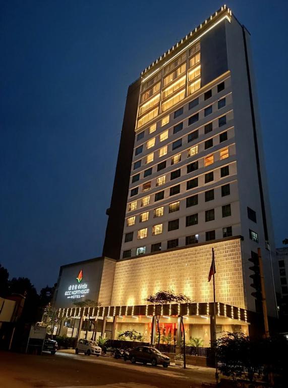 a tall building with cars parked in front of it at GCC North Side in Mumbai