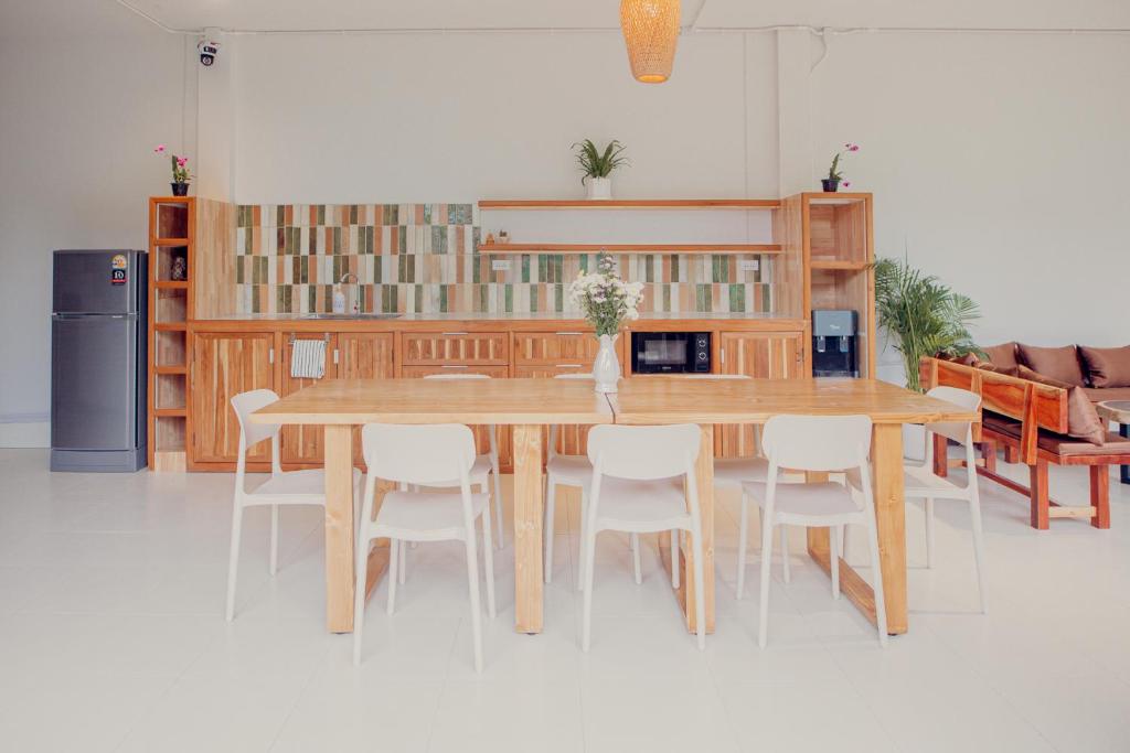 a dining room with a wooden table and chairs at Ark Guesthouse in Pai