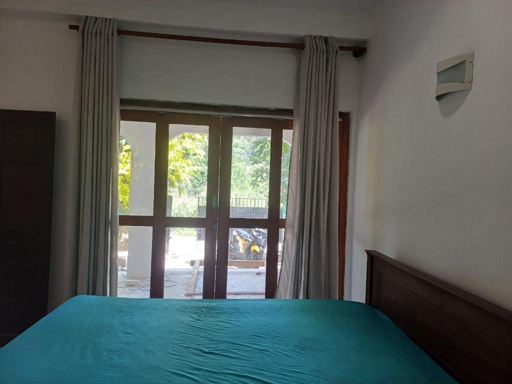 Un dormitorio con una cama y una ventana grande. en villa Calm Haven, en Unawatuna