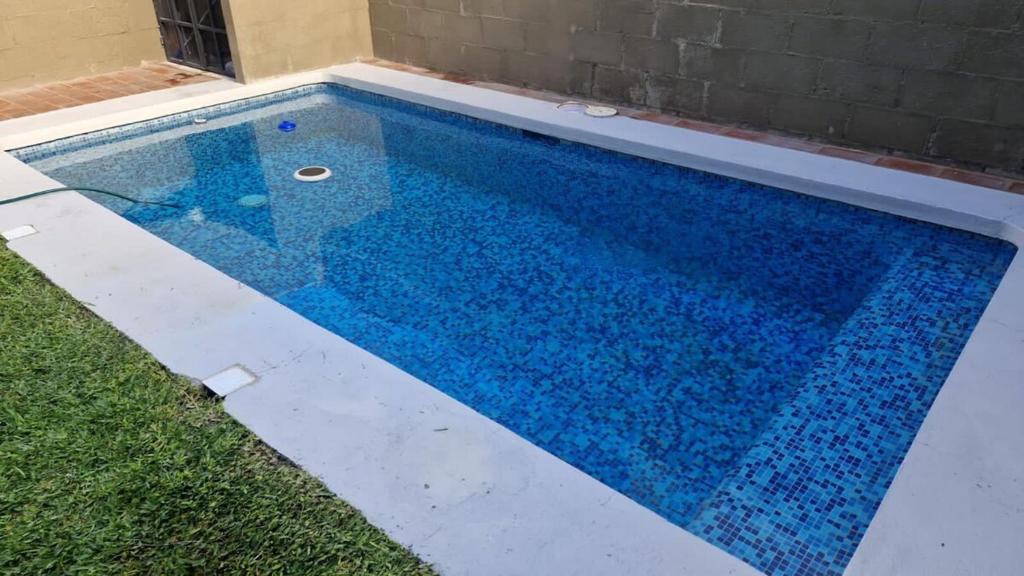 Una piscina con agua azul en un patio. en House with a private heated pool, en Atlacholoaya