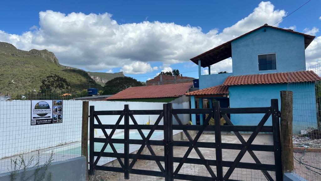 una casa blu con un cancello davanti a una recinzione di Casa Azul do Capão a Palmeiras