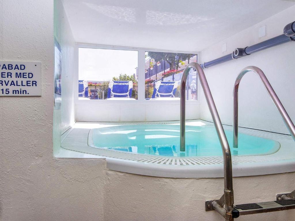 a bath tub in a bathroom with a sink at Holiday home on a holiday park in Glesborg in Glesborg