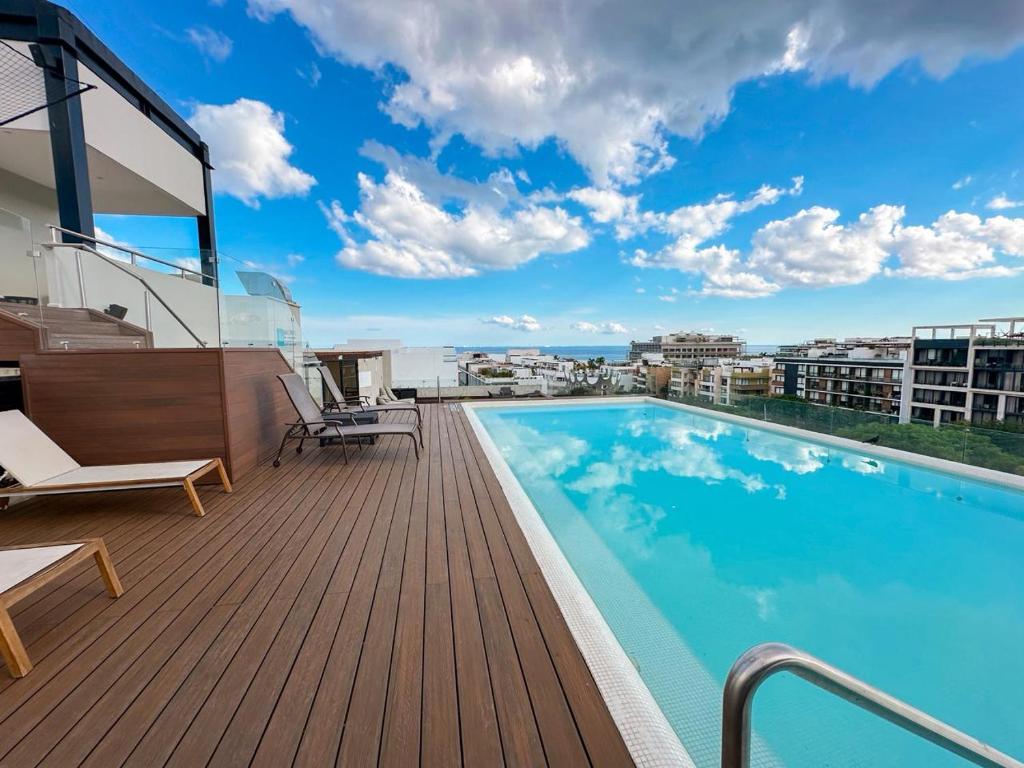 un balcon avec une piscine sur le toit d'un immeuble dans l'établissement Zuhause Apartments 5th AV, à Playa del Carmen