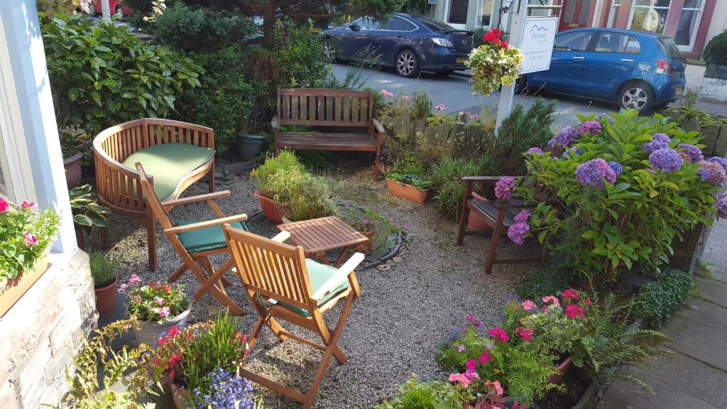 a garden with chairs and plants and flowers at Bluestones in Keswick