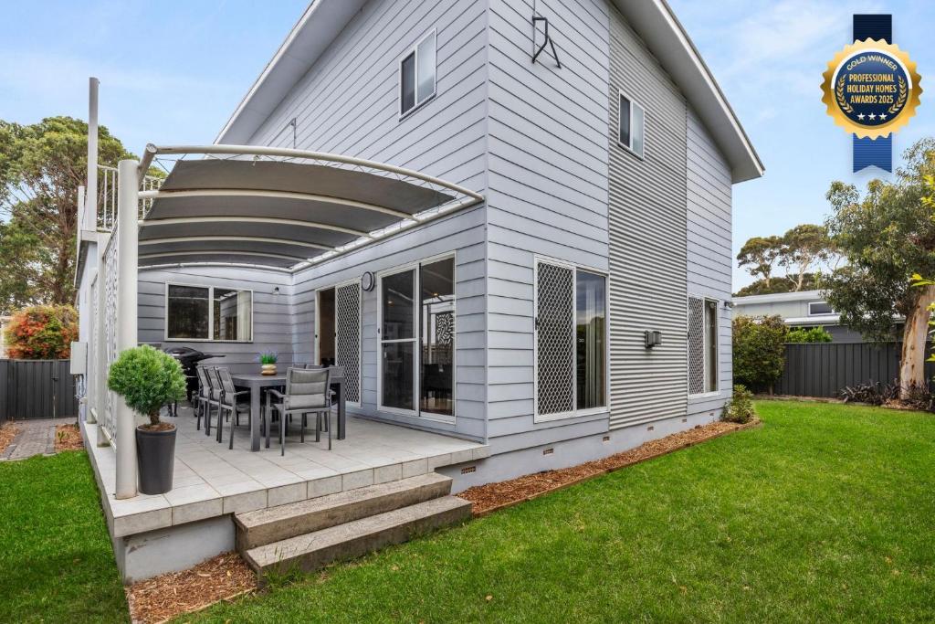 Un patio con una mesa y sillas en una casa. en Sandlewood Breeze - Pet Friendly - Community Pool, en Callala Beach