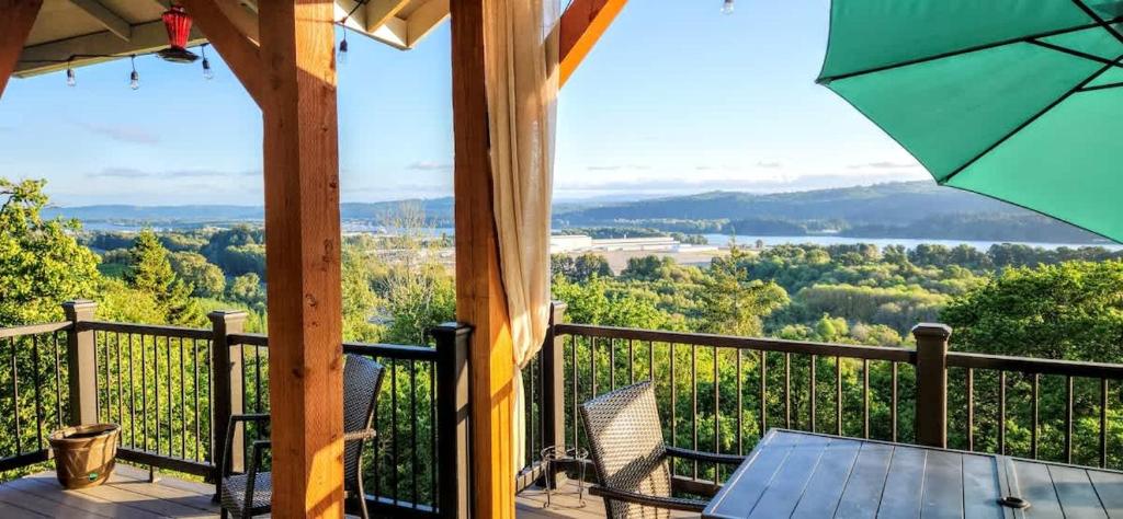 een uitzicht vanaf het terras van een hut met een tafel en stoelen bij Panoramic River Views - Nature Framed in Every Window in Kalama