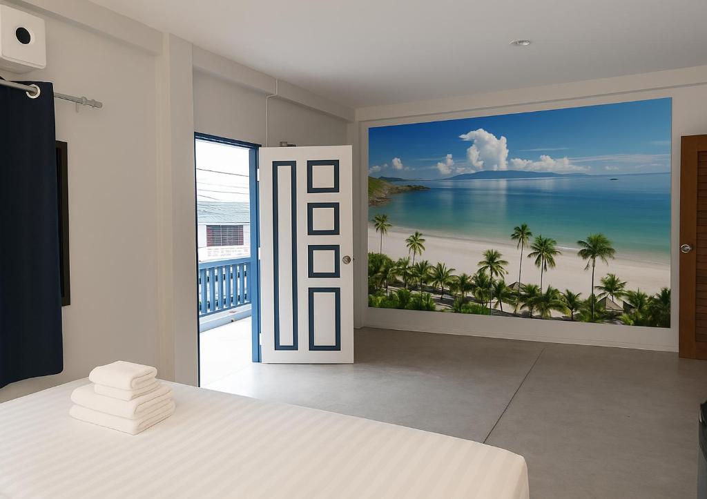 a bedroom with a view of the ocean and a bed at Mt Olympus Retreat Hotel in Mae Nam