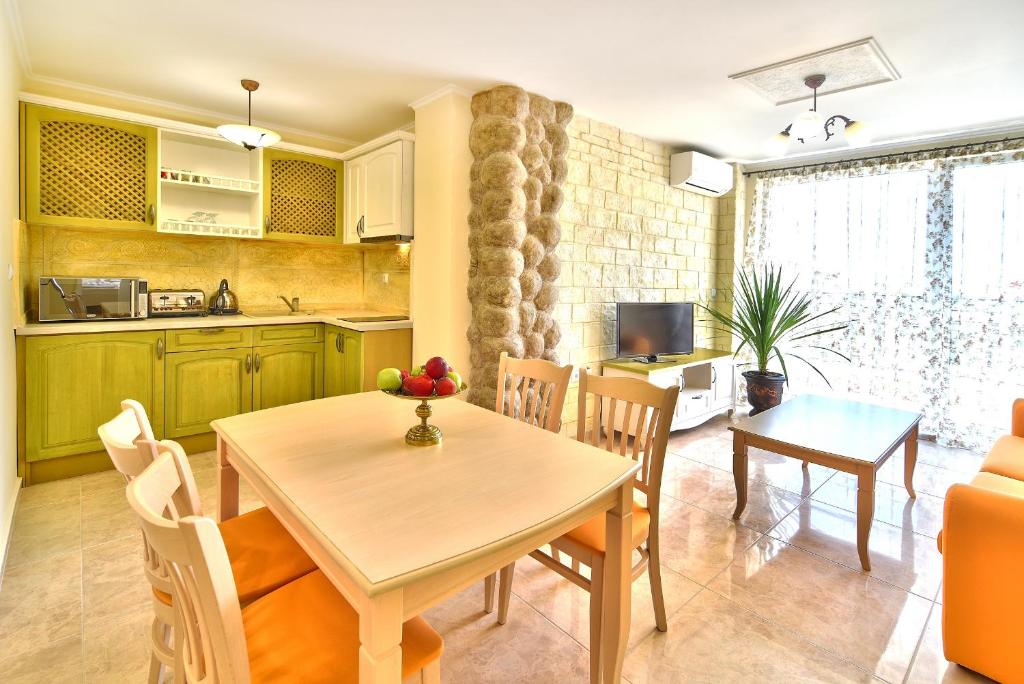 a kitchen and dining room with a table and chairs at Sirena Palace Family Hotel in Obzor
