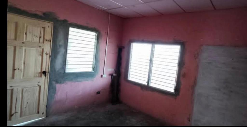 um quarto vazio com duas janelas e uma porta em Residencia Sánchez em David