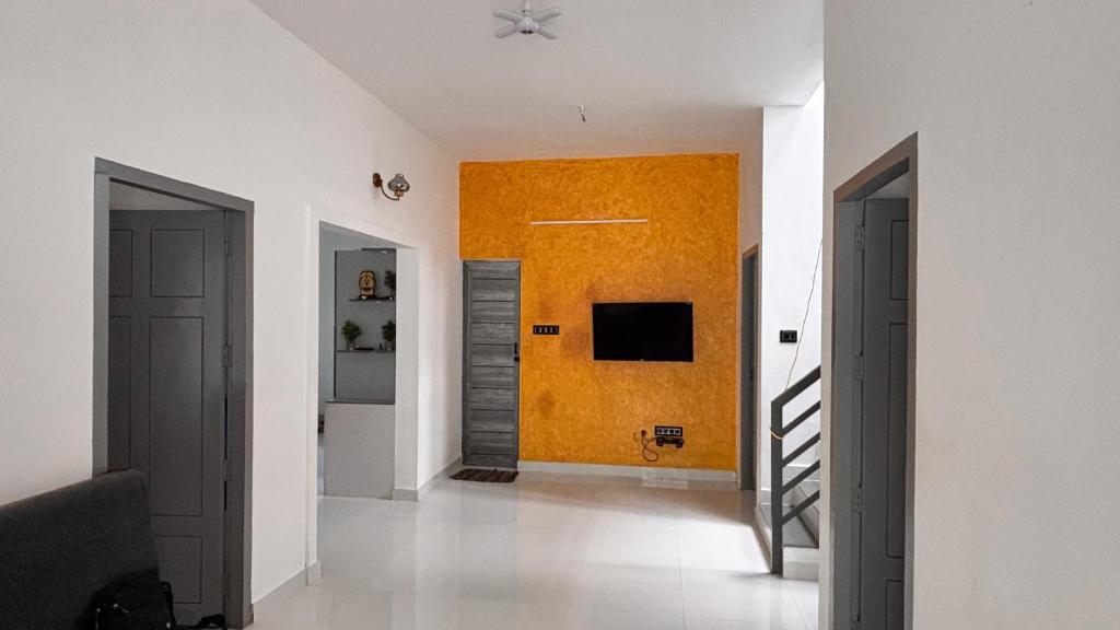 a hallway with two doors and a yellow wall at Thanal in Trivandrum