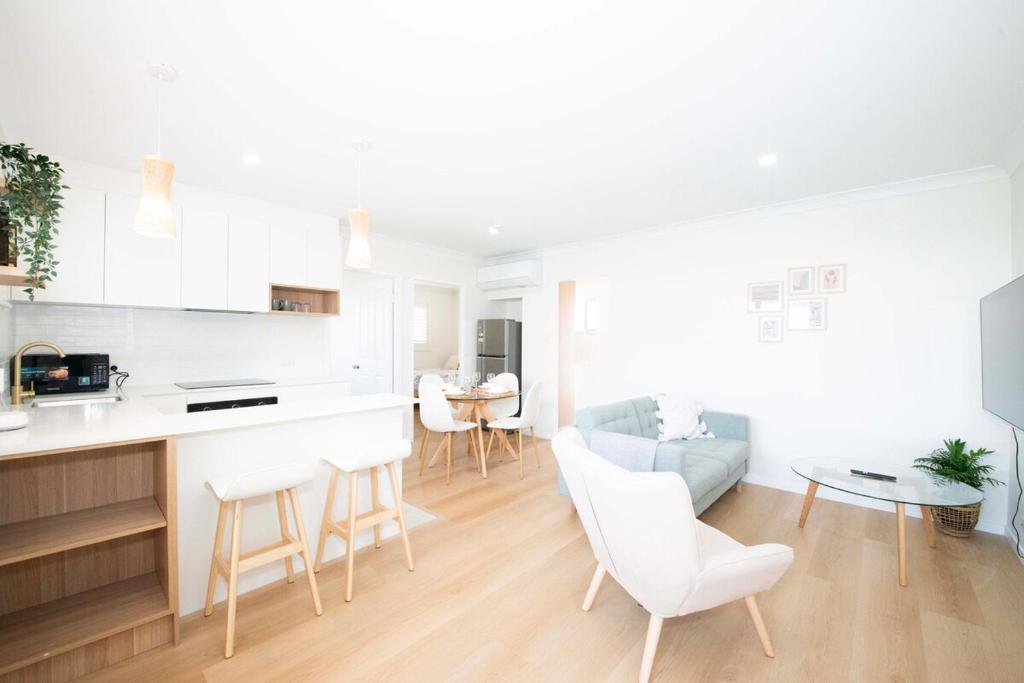 レッドクリフにあるAnchor at Redcliffe - Retreat on the Peninsulaのソファとテーブルのあるキッチンとリビングルーム