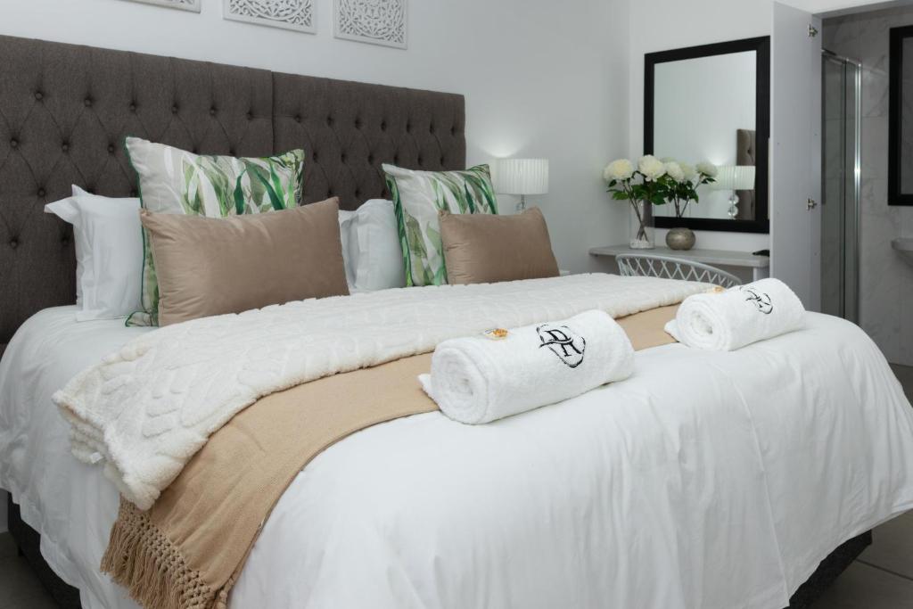 a bedroom with a large white bed with towels on it at Relmies Place in Modimolle