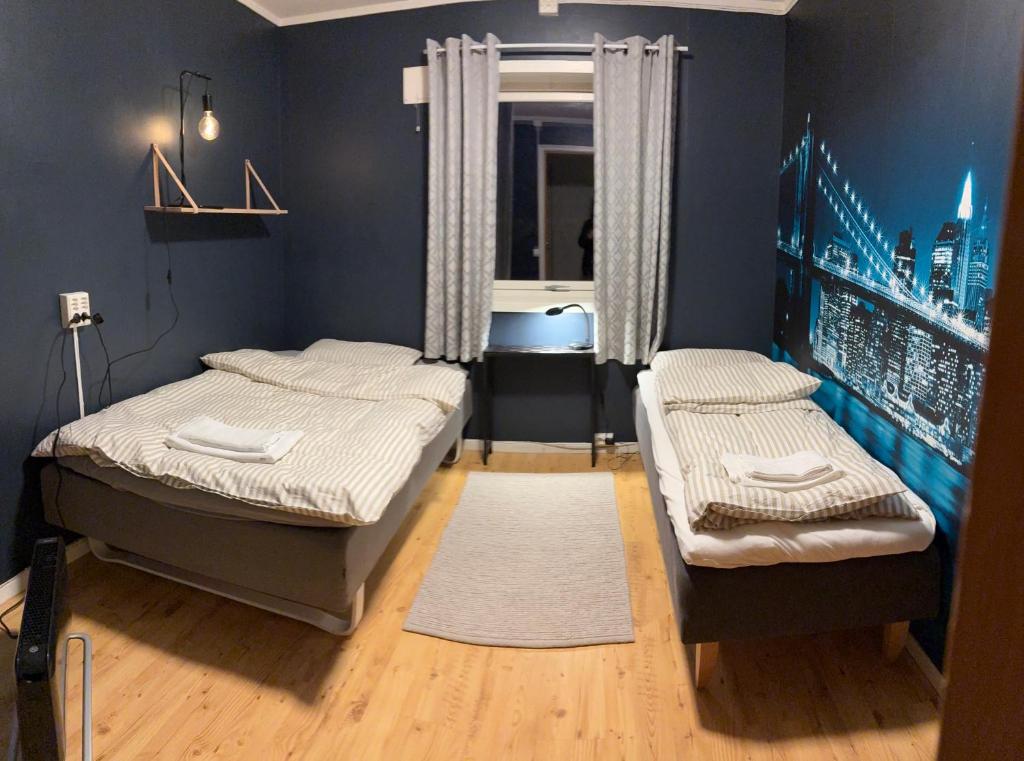 a bedroom with two beds and a window at Lillian's gjestehus, Skibotn in Skibotn