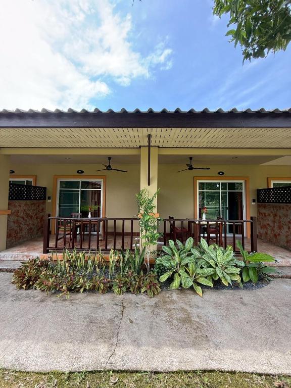 a house with a table and some plants at Sweet Mango Khaolak in Khao Lak