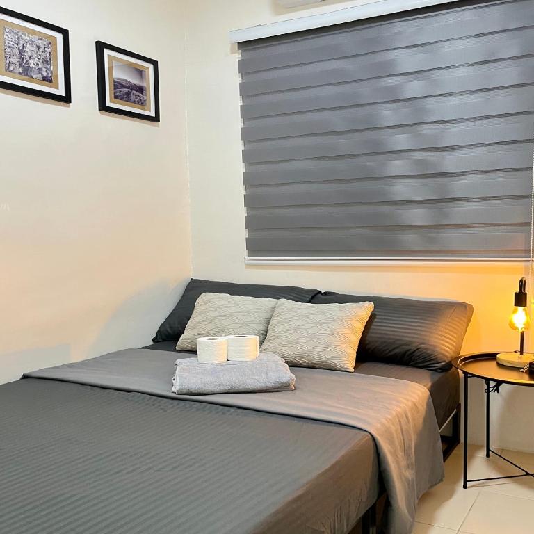 a bed with two towels on top of it in a room at Cozy 2 Bedroom Home in Lucena with AC and Fast WiFi in Ilayang Dupay