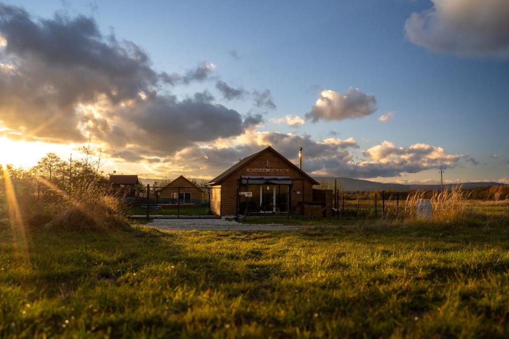 a building in the middle of a field at Wilcza Polana Domki koło Międzygórza z jacuzzi i sauną in Jaworek