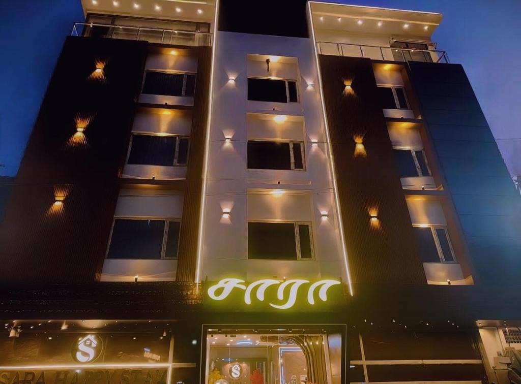 ティルヴァンナーマライにあるSara Happy Stay Hotelの前に看板がある高い建物