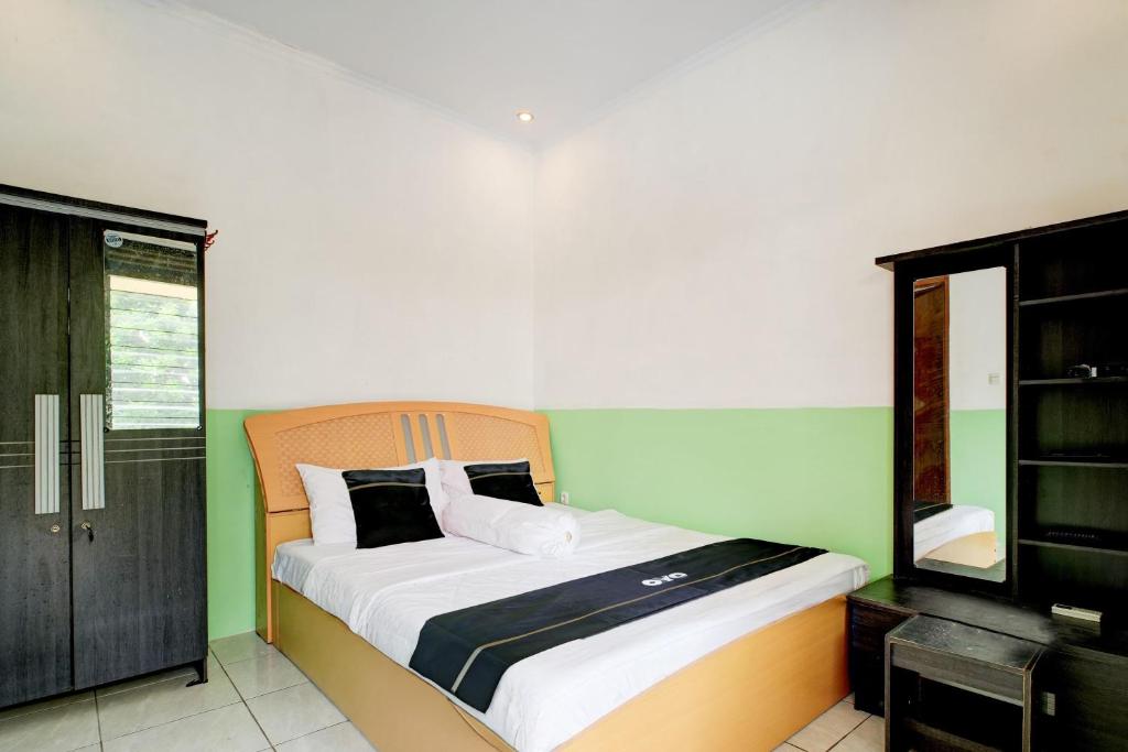 a bedroom with a bed with green and white at Hotel O Griya Cewang Syariah in Bekasi