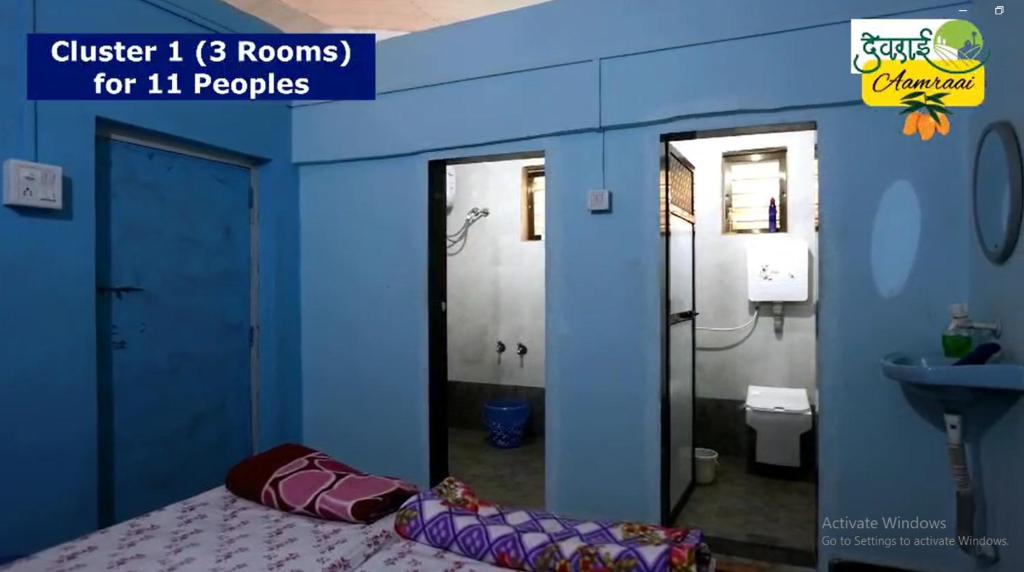 a blue room with a bed and a bathroom at Devraai Homestay 