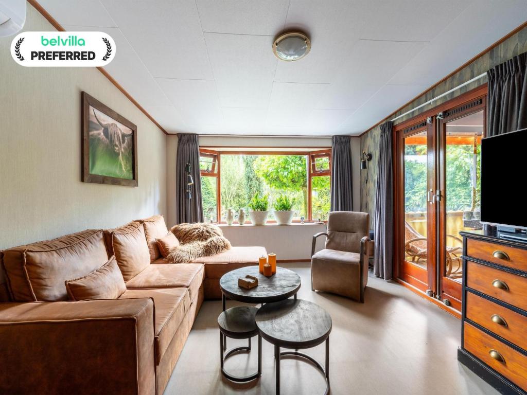a living room with a couch and a table at Chalet in Stegeren near Forest and Pond in Stegeren