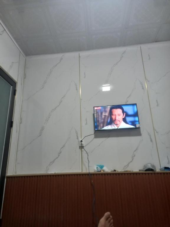 a tv on a white wall in a room at Mai homestay in Mỹ Lại (5)