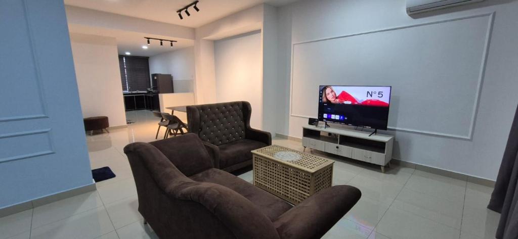 a living room with a couch and a tv at Wonder Villa in Bandar Penawar