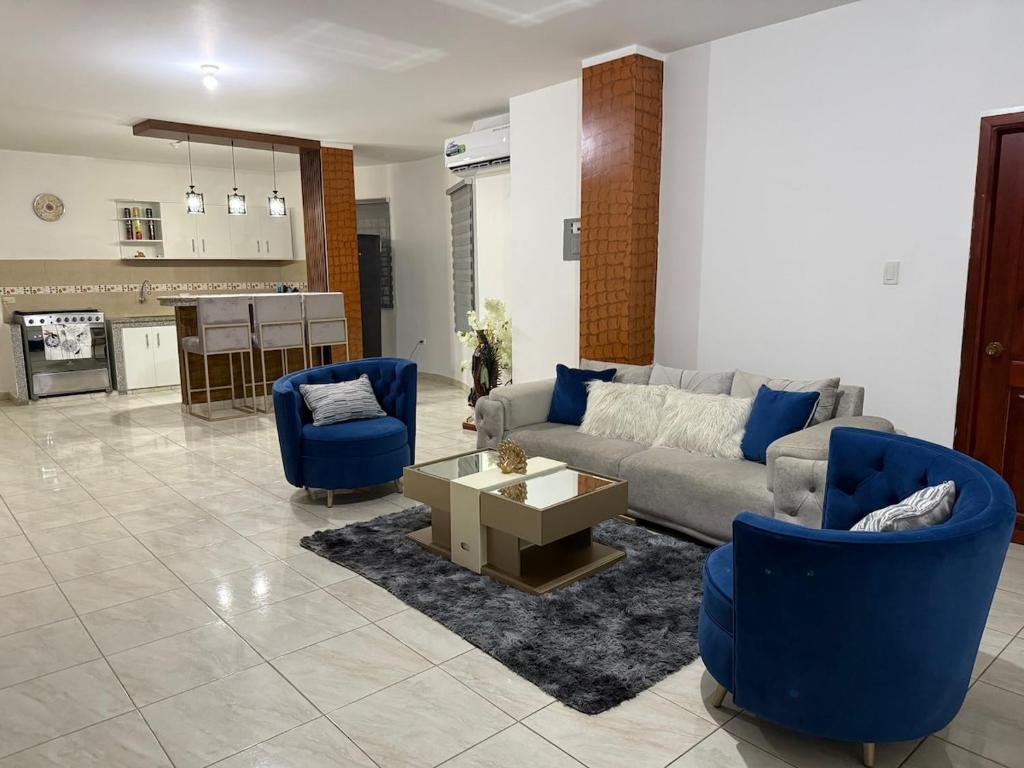 a living room with a couch and two blue chairs at LibiMar in Manta