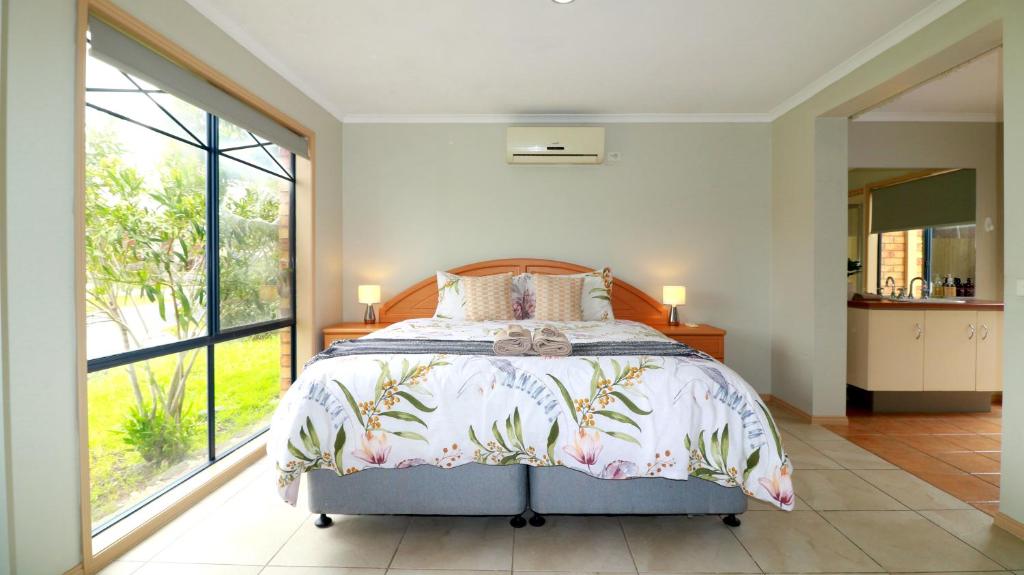 a bedroom with a bed and a large window at Sweet Home at Carrum Downs in Carrum Downs
