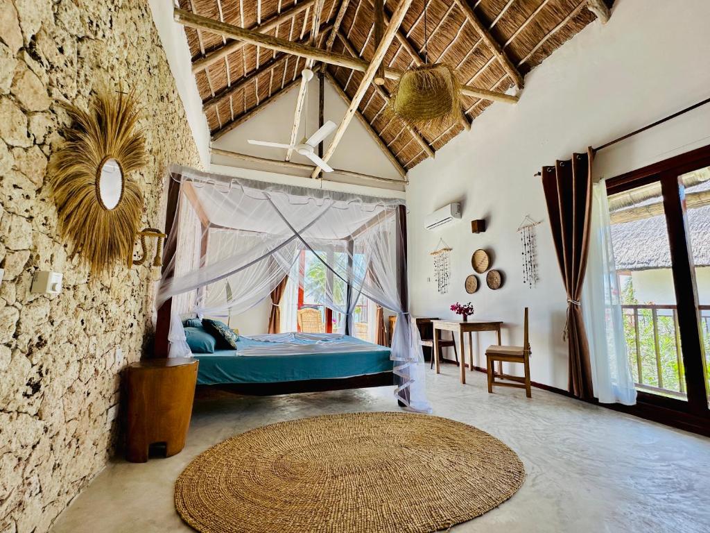 a bedroom with a bed and a table in a room at Beach Front Villa Ocean View Zanzibar in Pongwe