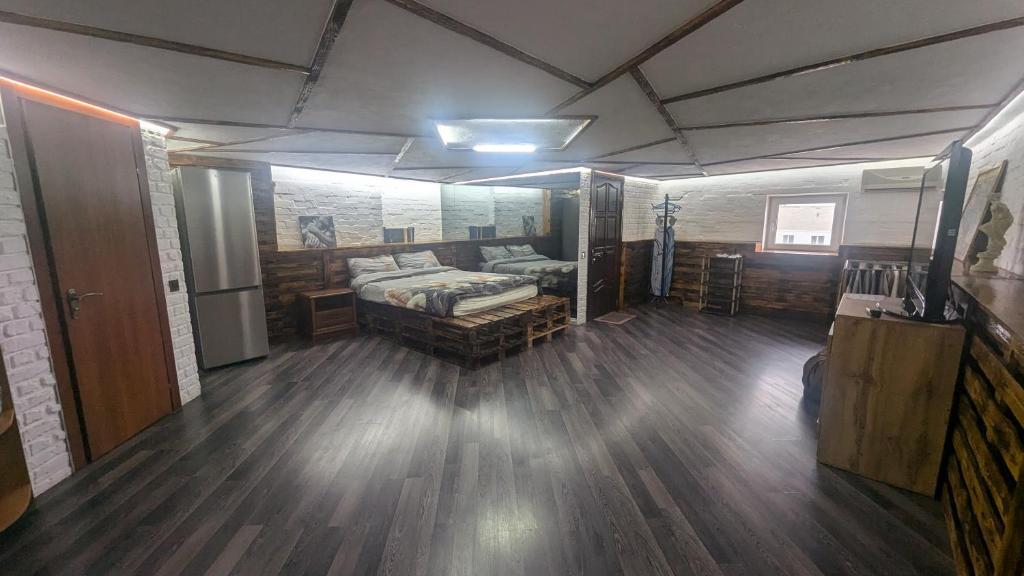 Großes Zimmer mit einem Bett und Holzböden. in der Unterkunft Смарт квартира в стилі лофт в самому центрі міста in Sumy