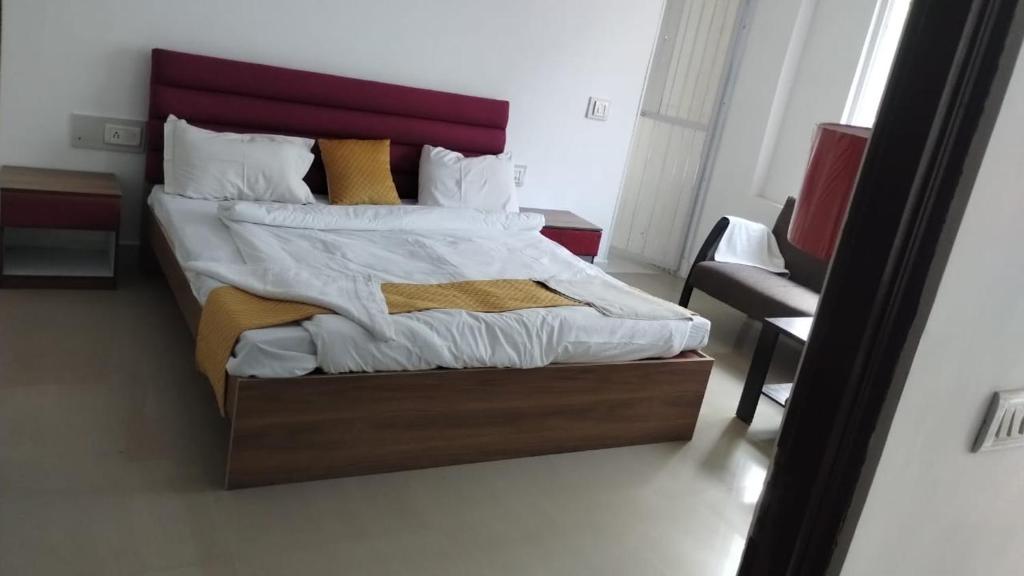 a bedroom with a large bed with a red headboard at Soooper Hotel 2 in Jāmb