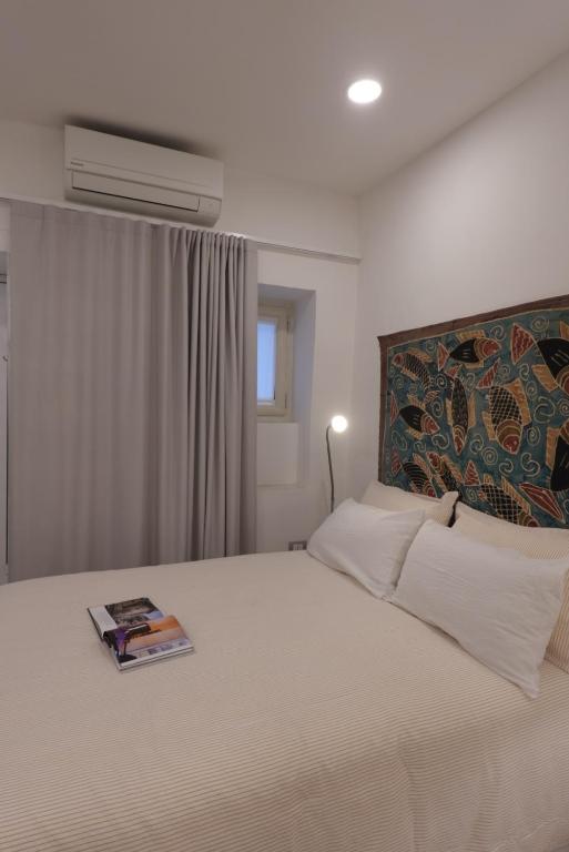 a bedroom with a bed with a book on it at Chiarù in Naples