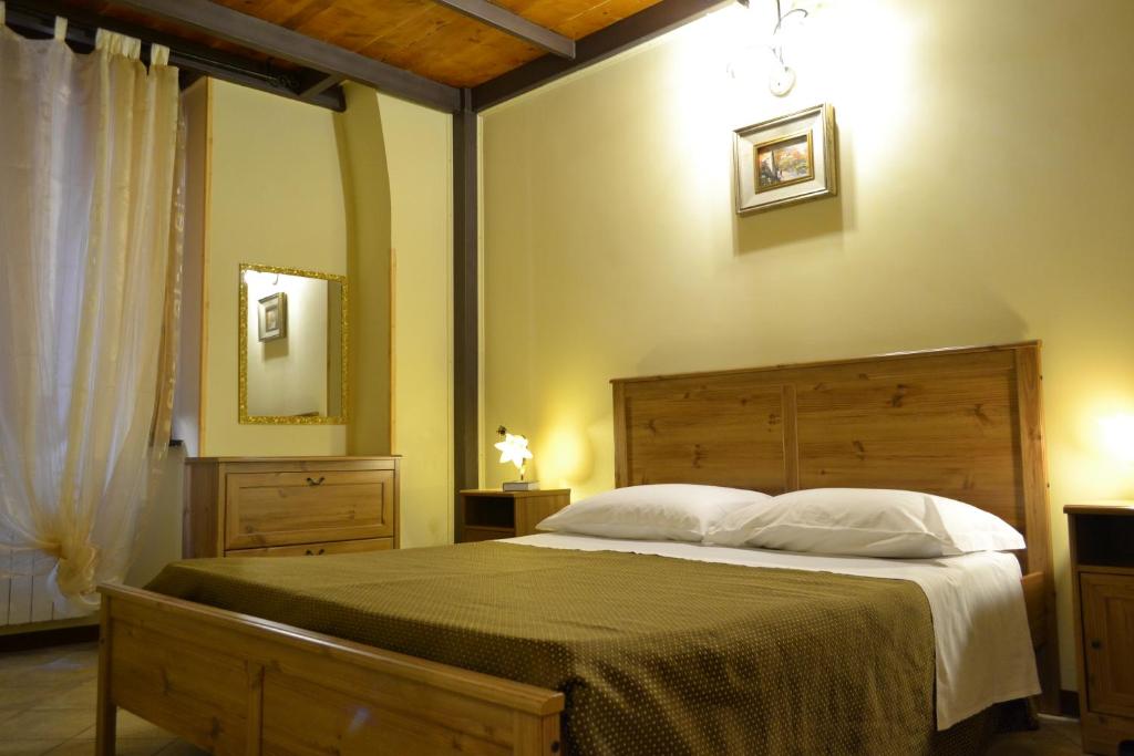 1 dormitorio con 1 cama grande y espejo en Antiche Melodie, en Salerno