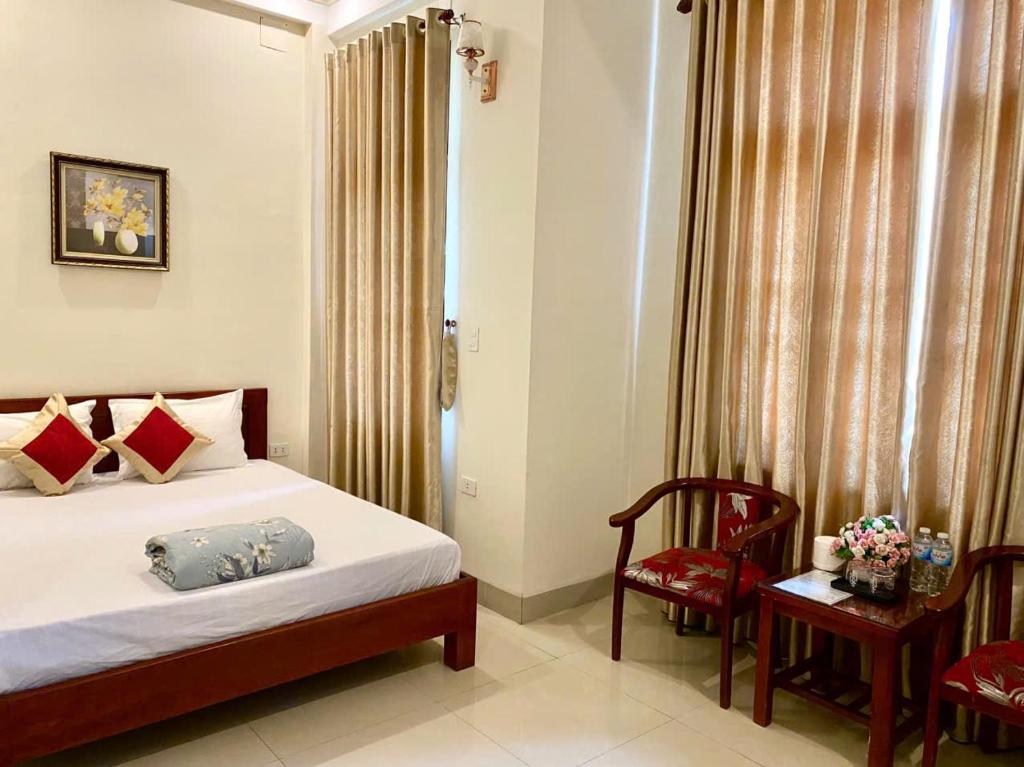 a bedroom with a bed and a chair and a table at Motel Rose in Hue