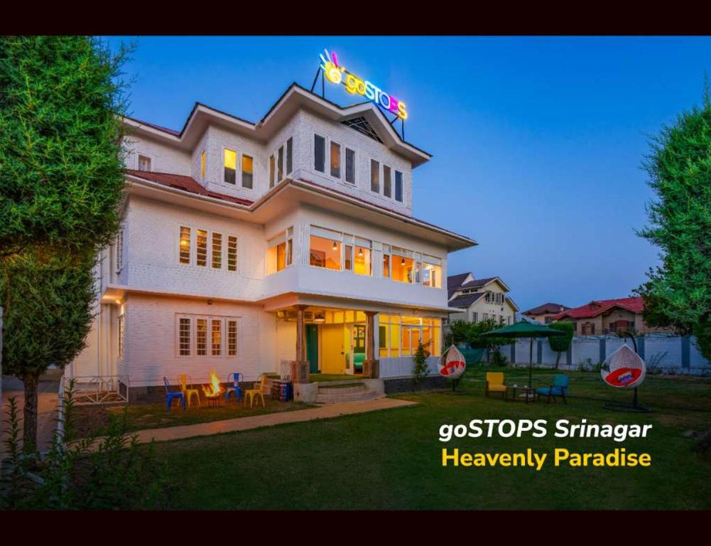 um grande edifício branco com um letreiro de néon em goSTOPS Srinagar em Srinagar