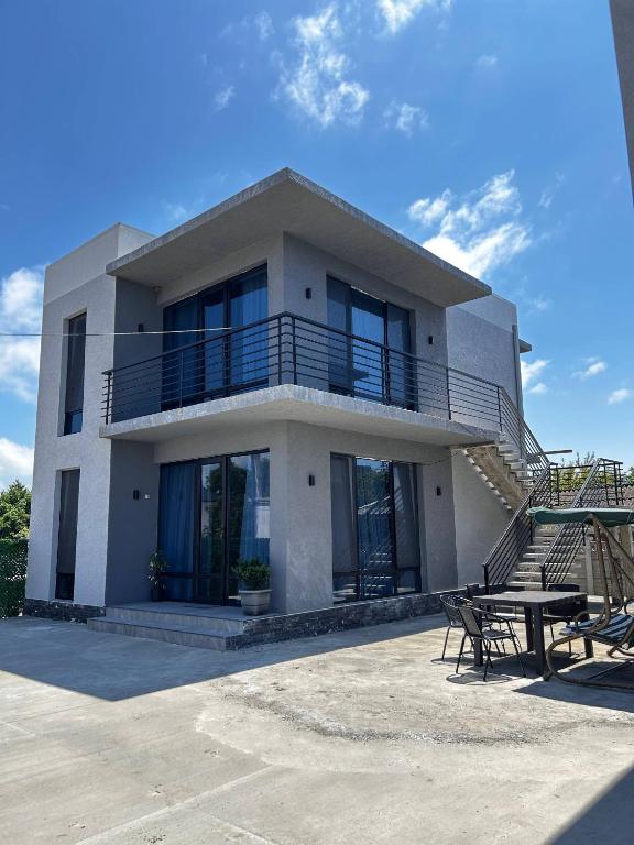 une maison avec un balcon et une table en face dans l'établissement Riverside Cotagge, à Poti