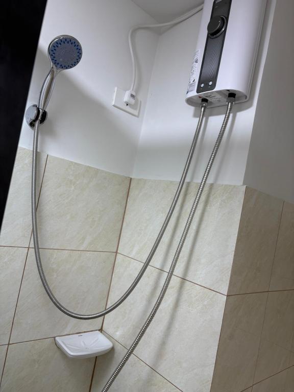 a shower with a hose hooked up to a wall at Azure Edge in Dauis