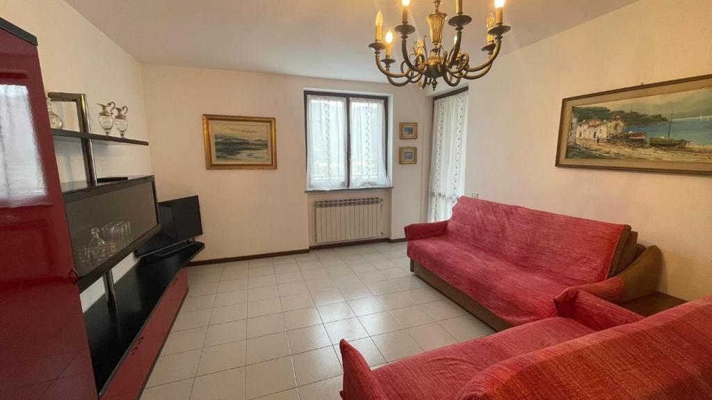 a living room with a red couch and a chandelier at Appartamento Torre 